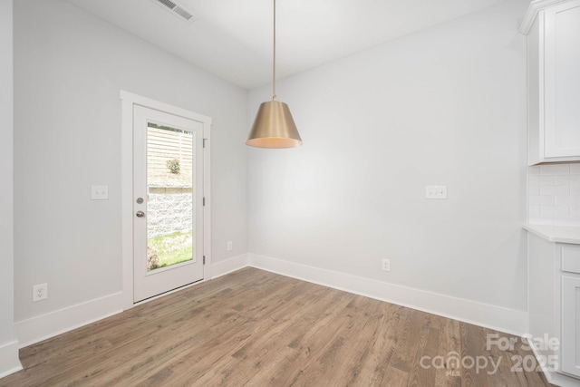 unfurnished dining area featuring wood-type flooring