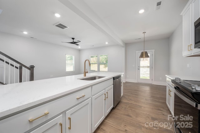 kitchen with pendant lighting, sink, white cabinets, light stone counters, and stainless steel appliances