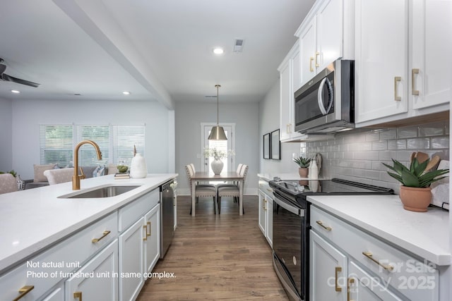 kitchen with stainless steel appliances, hanging light fixtures, sink, and white cabinets