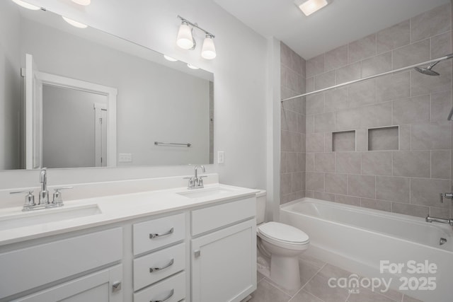 full bathroom featuring tile patterned floors, vanity, toilet, and tiled shower / bath combo