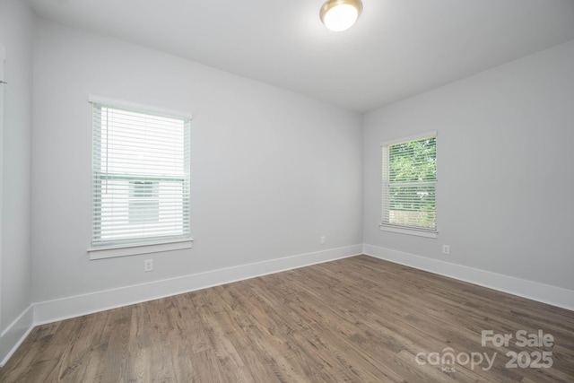 unfurnished room with hardwood / wood-style flooring