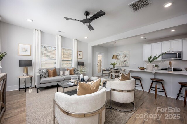 living room with recessed lighting, visible vents, light wood-style floors, and ceiling fan