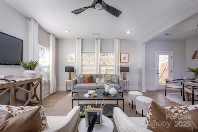 living area featuring recessed lighting, wood finished floors, visible vents, and baseboards