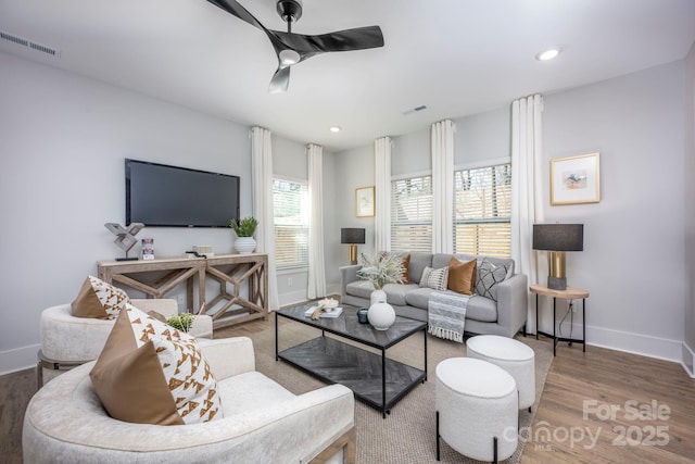 living area featuring a ceiling fan, wood finished floors, visible vents, baseboards, and recessed lighting