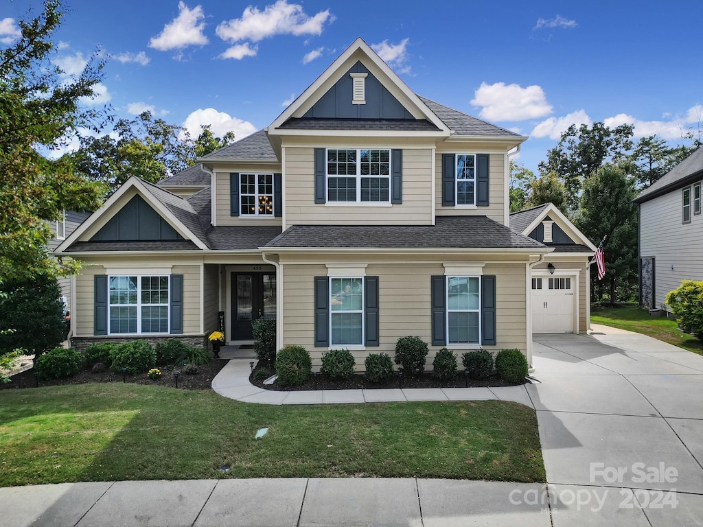 craftsman inspired home with a front lawn and a garage