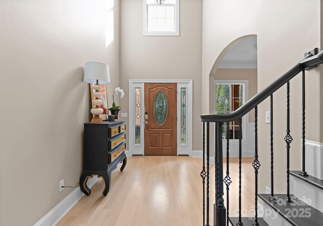 foyer with light hardwood / wood-style flooring and ornamental molding