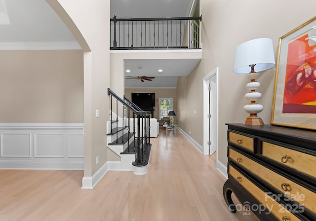 entrance foyer featuring crown molding, ceiling fan, and light hardwood / wood-style floors