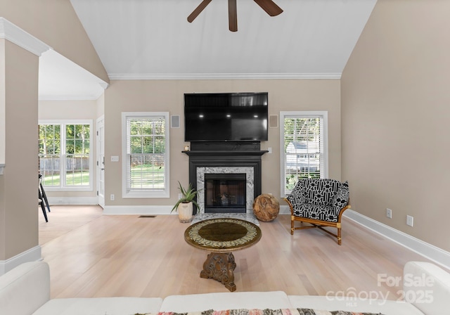 living room featuring plenty of natural light, ceiling fan, a fireplace, and vaulted ceiling