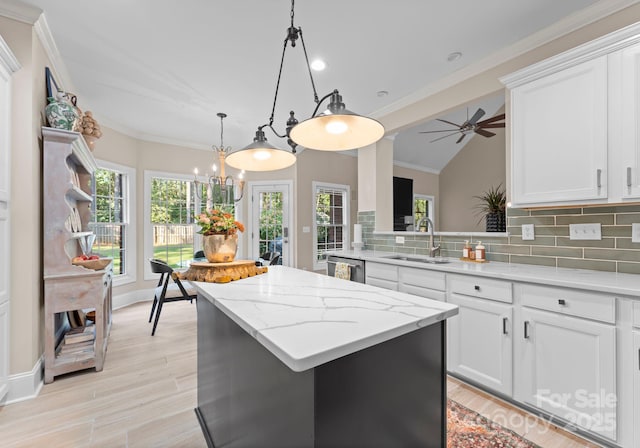 kitchen featuring backsplash, sink, white cabinets, and a kitchen island