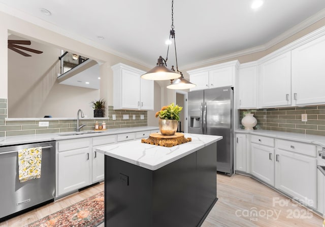 kitchen featuring white cabinets, sink, a center island, and appliances with stainless steel finishes