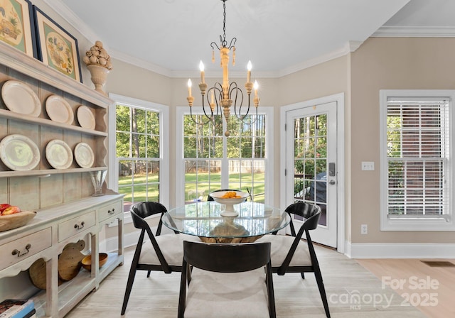 dining space featuring a healthy amount of sunlight, light hardwood / wood-style floors, crown molding, and a notable chandelier