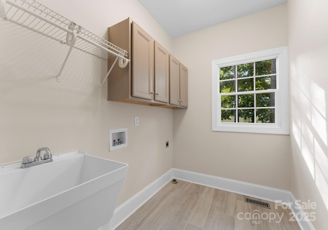 washroom featuring electric dryer hookup, cabinets, sink, washer hookup, and light wood-type flooring