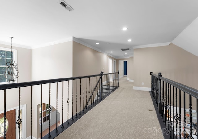 hallway with lofted ceiling, light colored carpet, and ornamental molding