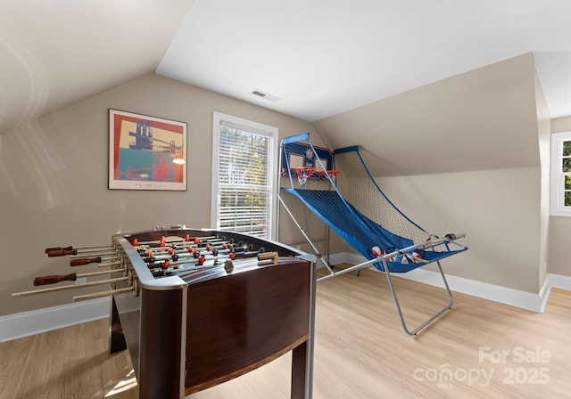 rec room with light wood-type flooring and vaulted ceiling