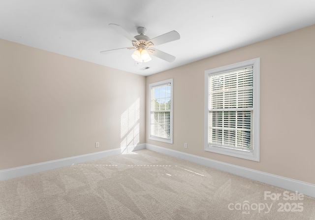 spare room with ceiling fan and light colored carpet