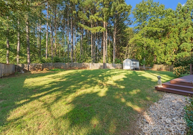 view of yard featuring a wooden deck and a storage unit