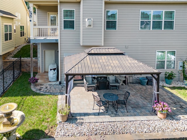 rear view of house with a gazebo, a lawn, a balcony, and a patio area