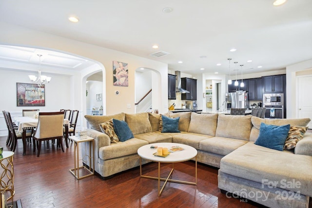 living room with an inviting chandelier, sink, and dark wood-type flooring