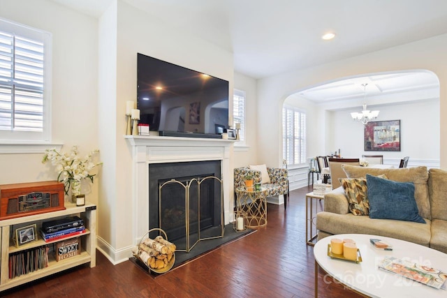 living room featuring a notable chandelier and dark wood-type flooring