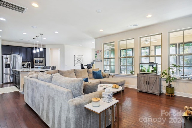 living room featuring ceiling fan, sink, and dark hardwood / wood-style flooring