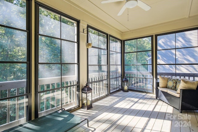 unfurnished sunroom with ceiling fan