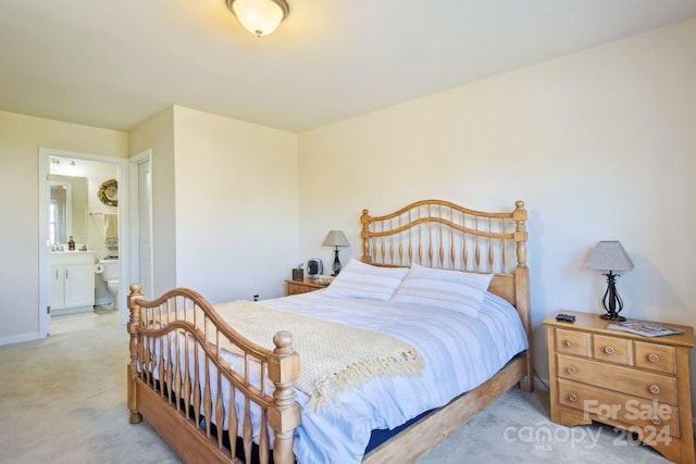 bedroom with light carpet and connected bathroom