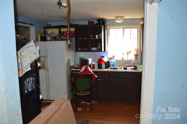 kitchen featuring a textured ceiling, sink, white refrigerator, and hardwood / wood-style floors