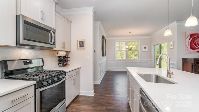 kitchen featuring decorative light fixtures, stainless steel appliances, an inviting chandelier, and sink