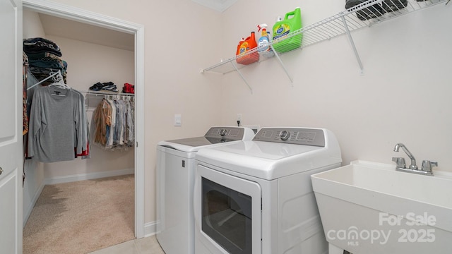 laundry area with sink, light colored carpet, and washer and dryer