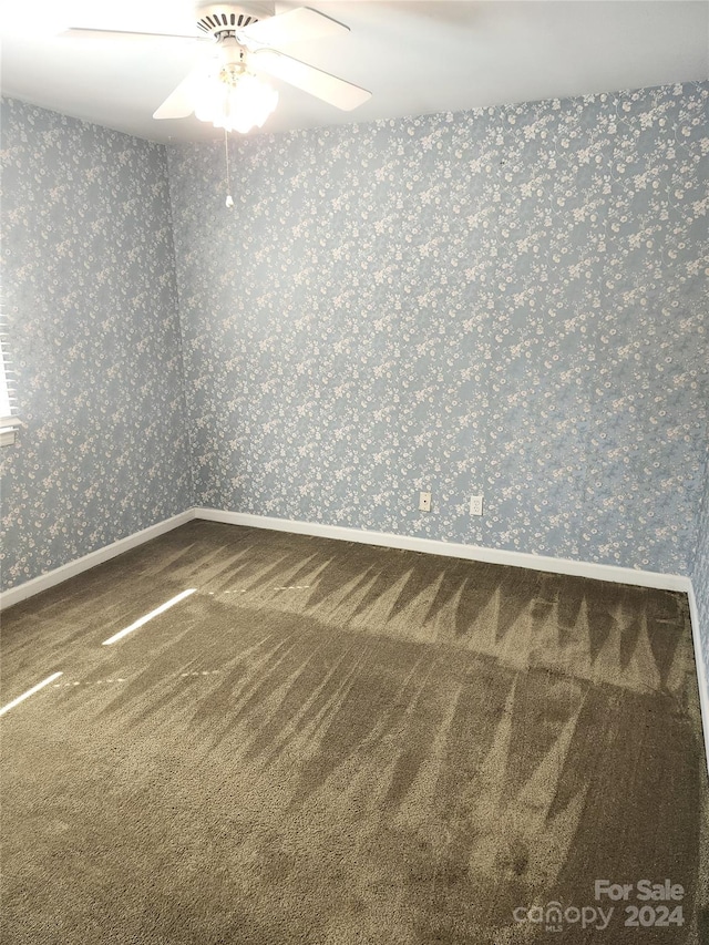 unfurnished room featuring ceiling fan and carpet flooring