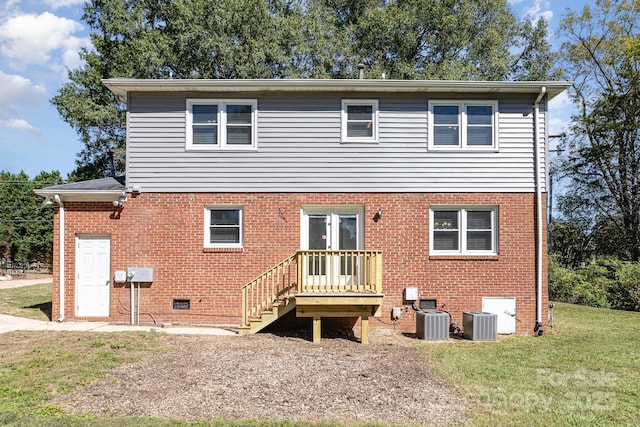 rear view of house with a yard, brick siding, crawl space, and central AC unit