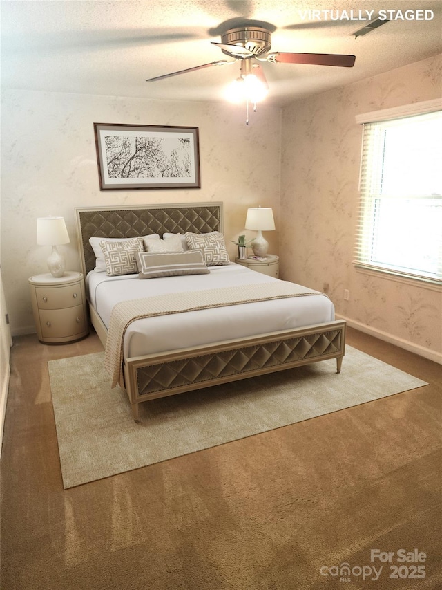 carpeted bedroom with wallpapered walls, baseboards, and a ceiling fan