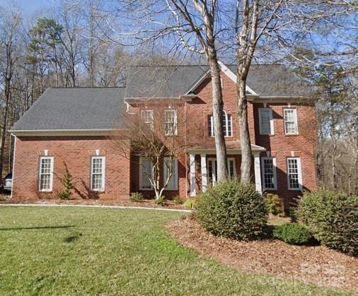 colonial house featuring a front lawn