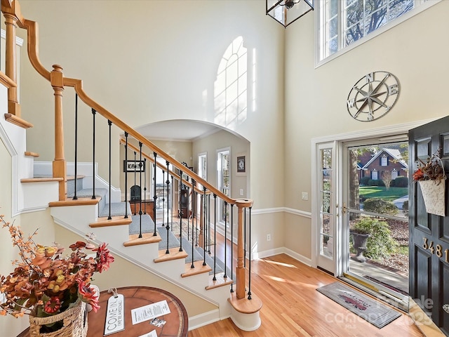 entryway with a towering ceiling and light wood-type flooring