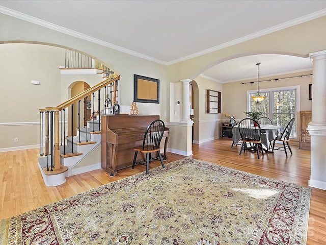 foyer entrance featuring ornamental molding, hardwood / wood-style floors, and ornate columns