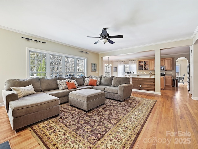 living room with crown molding, light hardwood / wood-style flooring, and ceiling fan