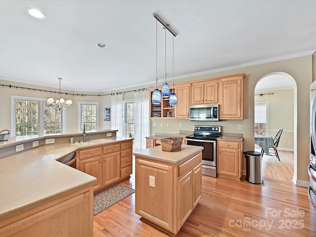 kitchen featuring sink, appliances with stainless steel finishes, hanging light fixtures, a center island, and light brown cabinets