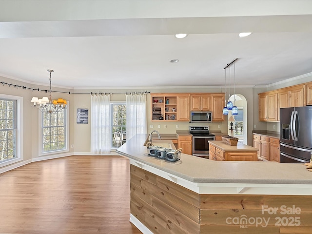 kitchen featuring appliances with stainless steel finishes, pendant lighting, sink, crown molding, and a spacious island