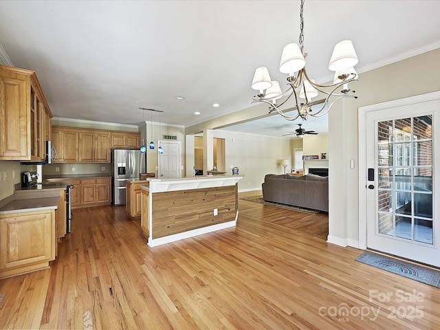 kitchen with crown molding, a center island, light hardwood / wood-style flooring, pendant lighting, and stainless steel appliances