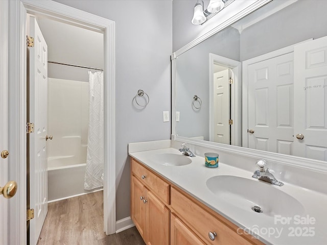 bathroom featuring hardwood / wood-style flooring, vanity, and shower / bathtub combination with curtain