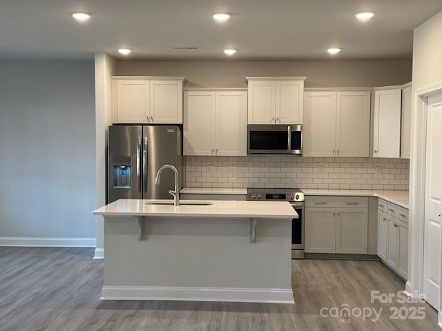 kitchen with white cabinetry, sink, hardwood / wood-style flooring, and stainless steel appliances