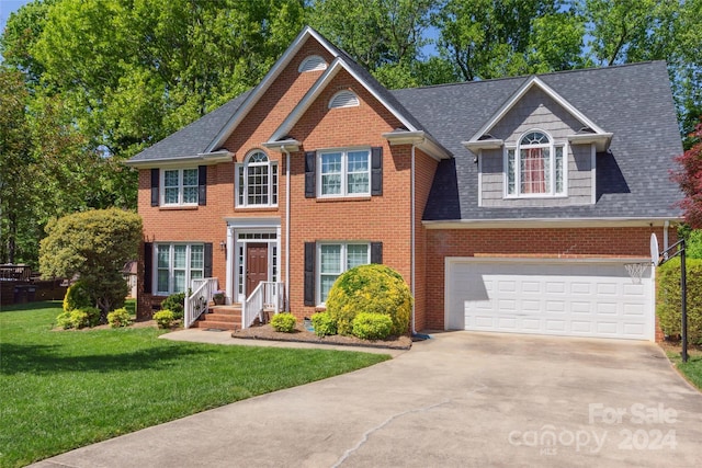 colonial home with a front yard and a garage