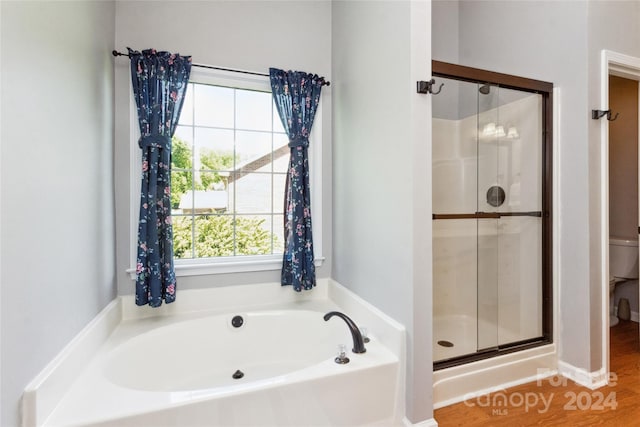 bathroom with hardwood / wood-style flooring, toilet, and independent shower and bath