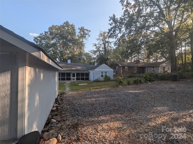 rear view of property featuring a sunroom