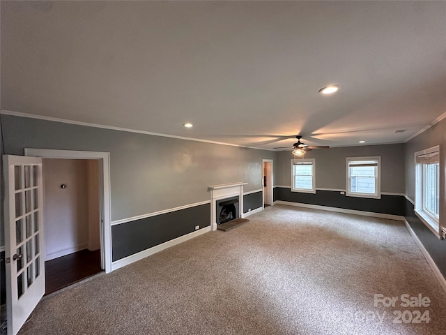 unfurnished living room featuring ornamental molding, ceiling fan, and carpet