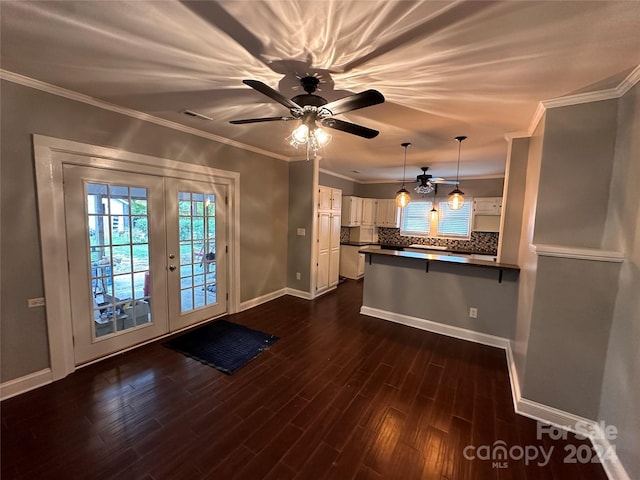 kitchen featuring french doors, white cabinets, crown molding, and dark wood-type flooring