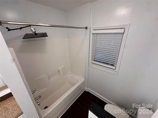 bathroom with shower / bathing tub combination, hardwood / wood-style floors, and toilet