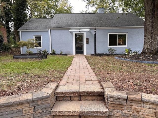 ranch-style house featuring stucco siding and a shingled roof