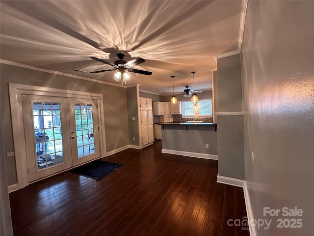 unfurnished living room featuring a ceiling fan, baseboards, dark wood-style flooring, french doors, and crown molding