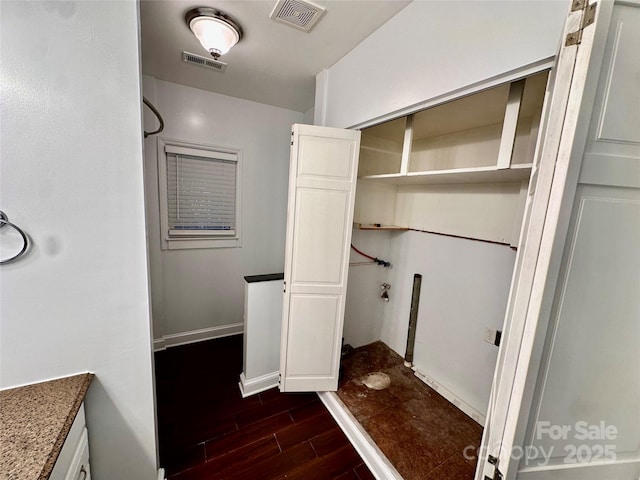 laundry area with baseboards, visible vents, and dark wood-style flooring